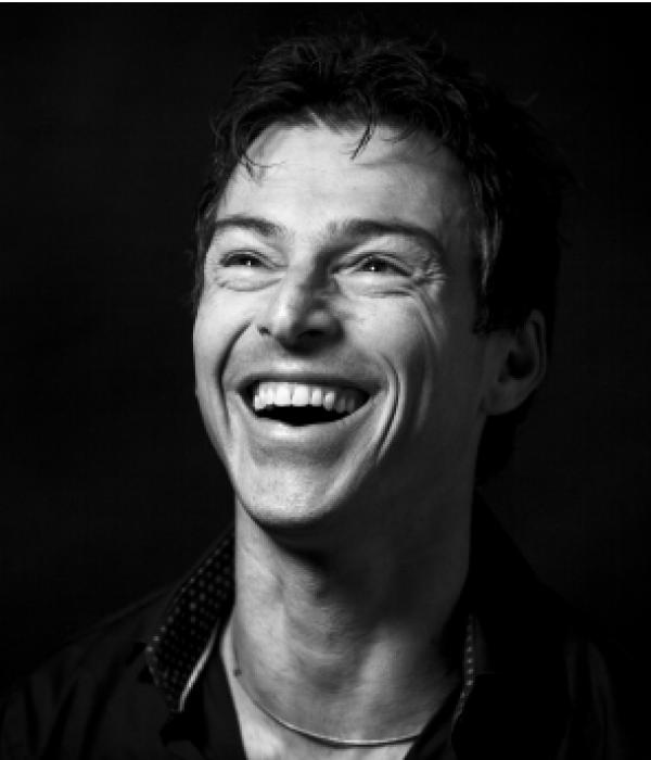 Schwarz-weiß-Porträt eines lachenden Mannes mittleren Alters